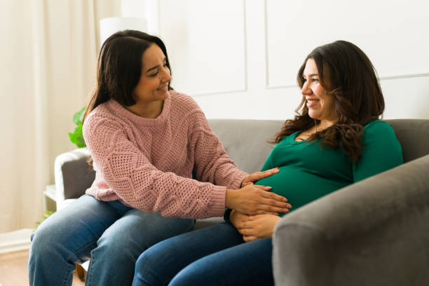 Doula comforting a pregnant client on a sofa